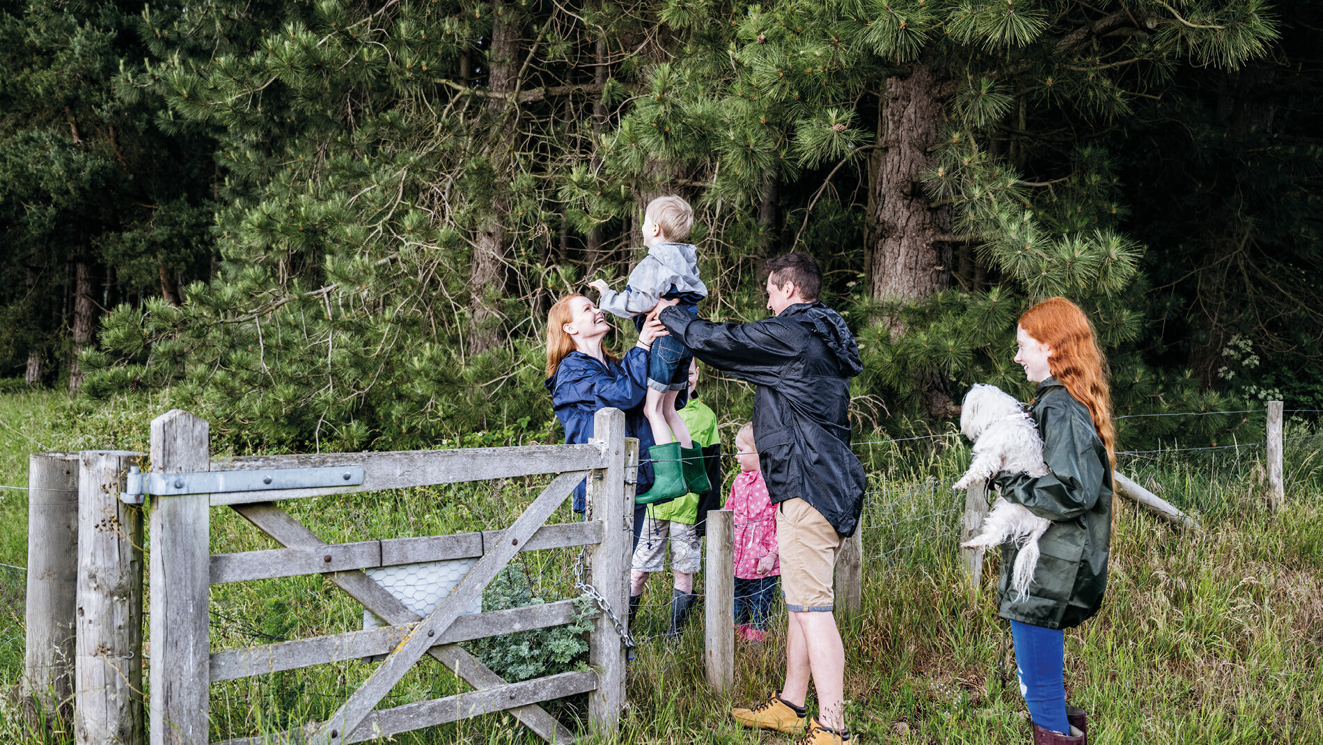 Familie bij een hek op wandelroute